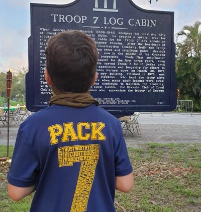 boy reading log cabin historic marker
