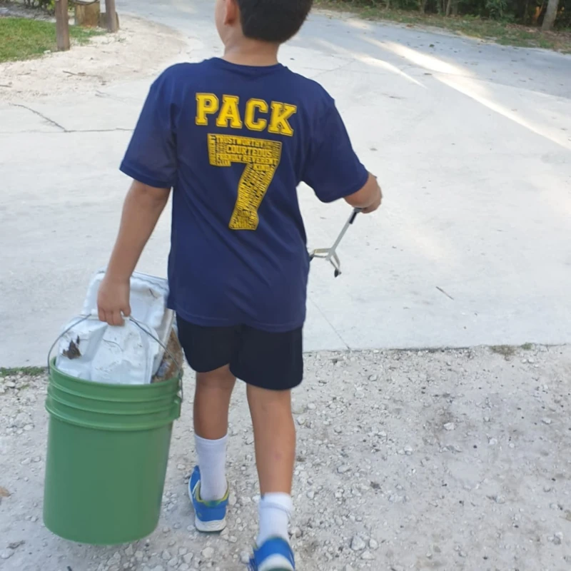 Cub carrying bucket of trash